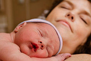 Midwife with newborn and mother